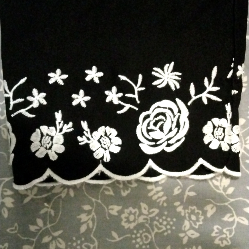 Black skinny ankle cut dress pants with pretty floral embroidery at the bottom.
